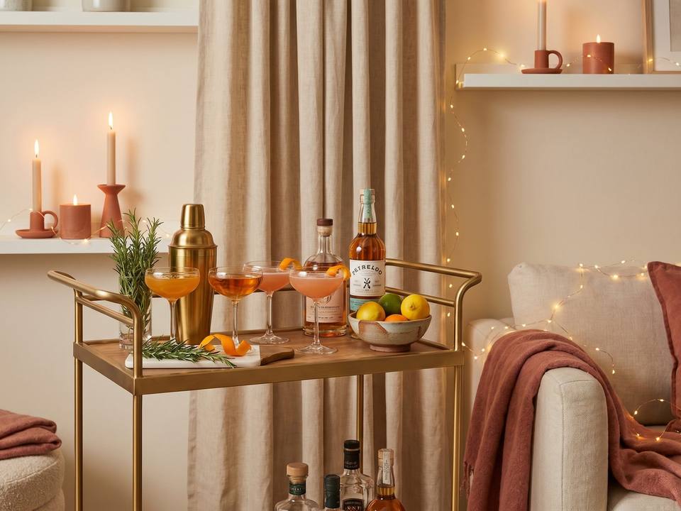 Eleganter Cocktailabend zuhause mit Barwagen, Coupé-Gläsern und Zitrusfrüchten